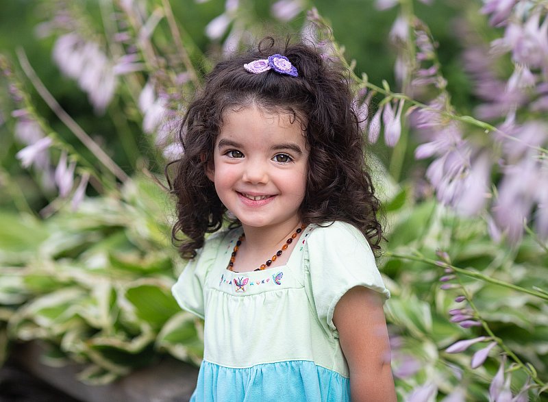 michigan child photographer beautiful toddler girl with curly dark hair flower background